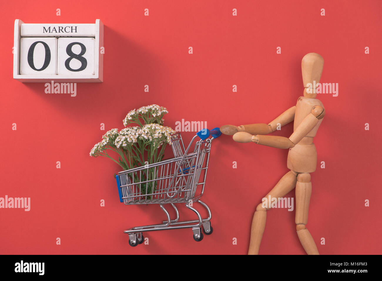 Einkaufswagen mit Blumen auf roten Hintergrund. Frau Tag einkaufen und verkaufen. Stockfoto