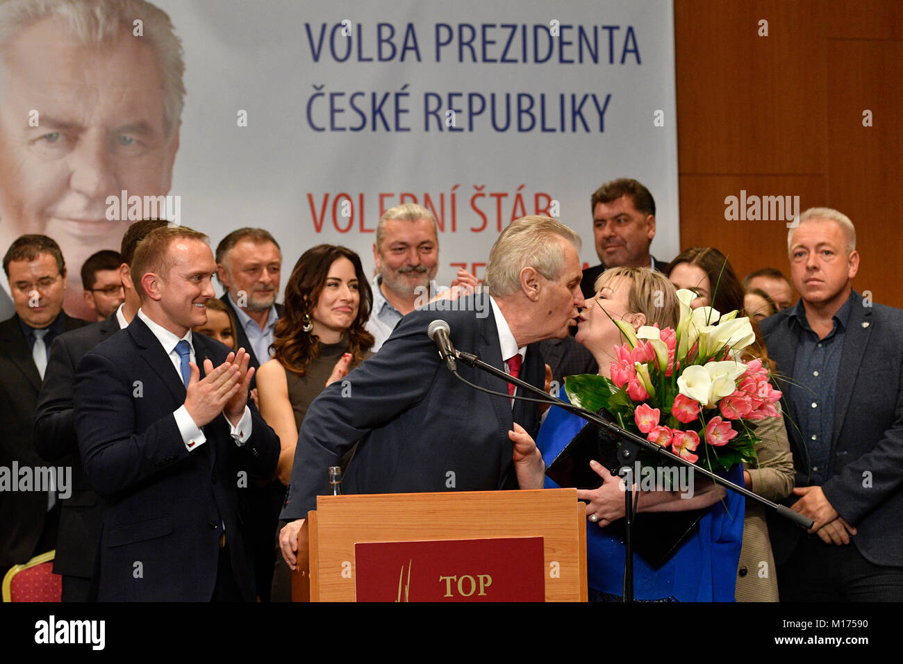 Die pro-russische etablierten Milos Zeman küsst seine Frau Ivana während sie behaupten, Sieg in der tschechischen Präsidentschaftswahl in Prag, Tschechische Republik, Samstag, Jan. 27, 2018. Der Tschechischen Republik pro-russische Präsident gewann eine zweite Amtszeit von fünf Jahren Samstag nach dem Sieg gegen ein politischer Neuling gesehen als mehr Western - in einer Stichwahl orientiert. Mit stimmzetteln von fast 99 Prozent der Wahllokale gezählt, das Tschechische Amt für Statistik sagte Präsident Milos Zeman 51,6 Prozent der Stimmen während des zweitägigen Stichwahl erhalten hatte. Im Hintergrund von links: Leiter des Präsidialbüros Protokoll Kapite Stockfoto