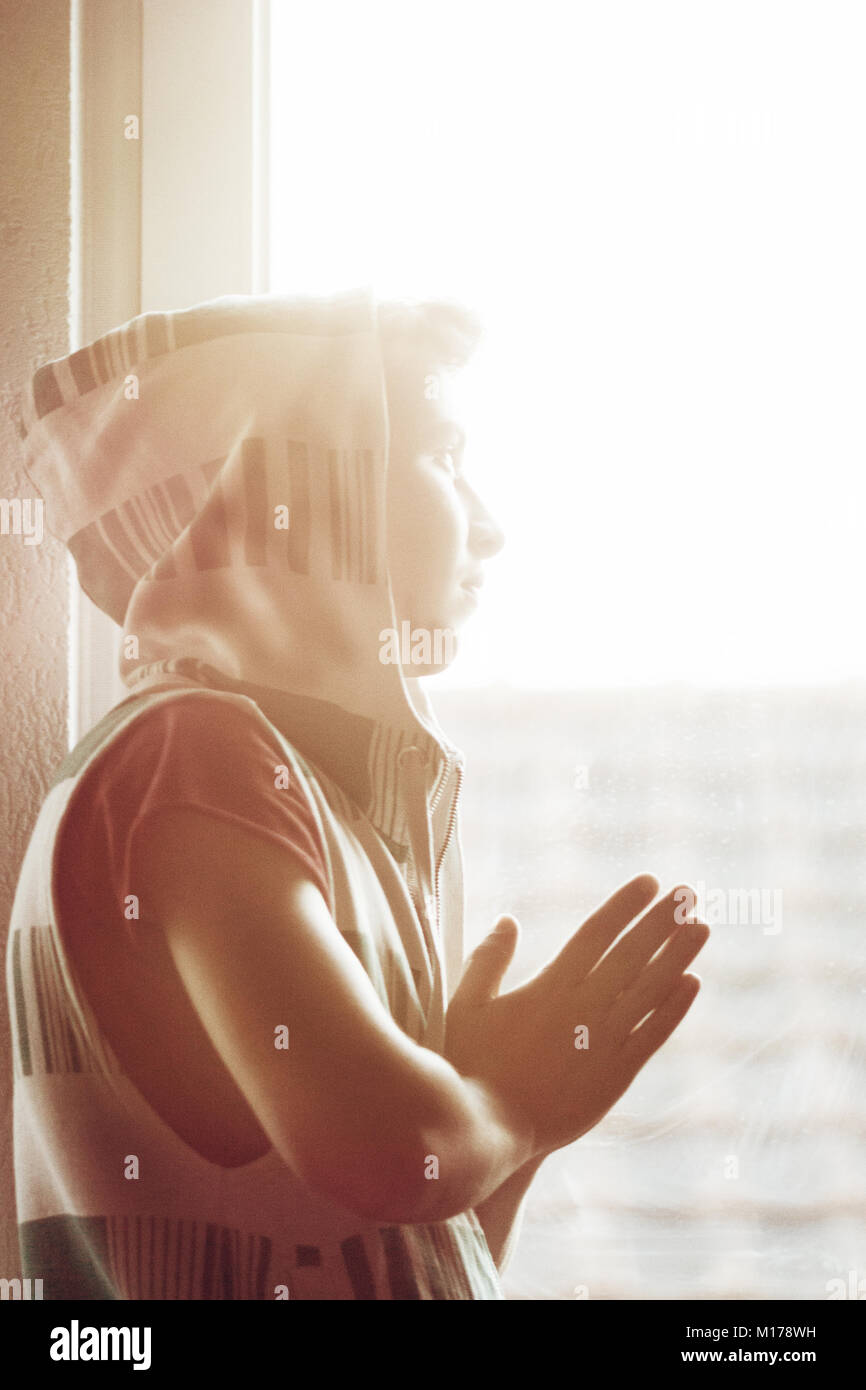 Teenager Junge mit hoodie auf der Suche nach Sonne und Beten Stockfoto