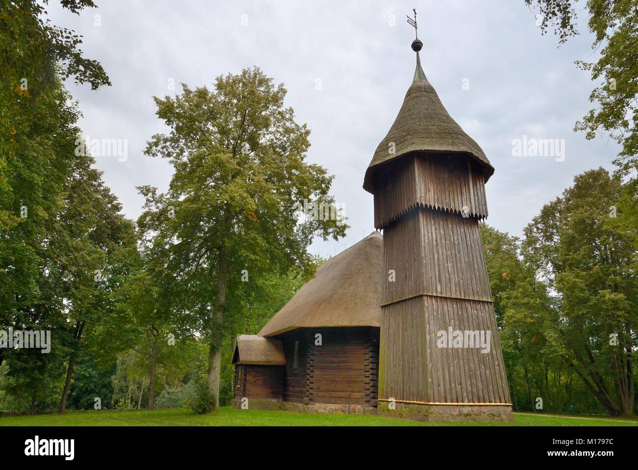 Alte hölzerne Kirche und Glockenturm mit Strohdächern aus Masuren, nun innerhalb der ethnographische Park, Olsztynek, Polen, September 2017. Stockfoto