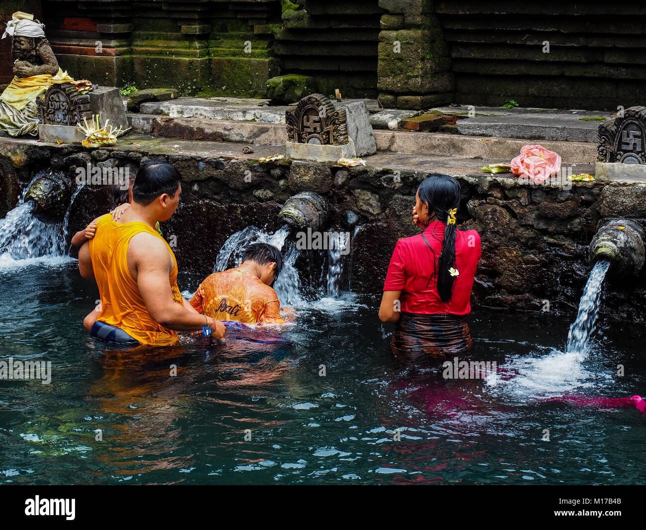 Balinesische Familie beten und Baden im Pura Tirta Empul - ein Hindu berühmten Tempel in Bali. Stockfoto