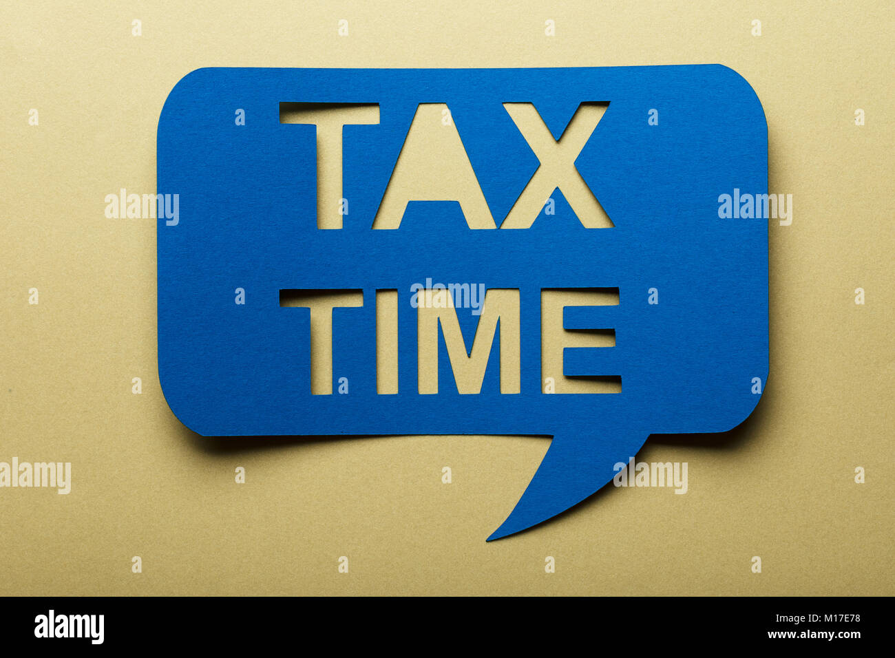 Blue Bubble Rede mit ausgeschnittenen Text Steuer Zeit auf braunem Hintergrund Stockfoto