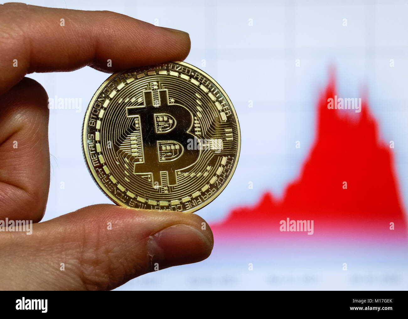 Bitcoin cryptocurrency Münze vor einem Computer Bildschirm mit bitcoin Chart Stockfoto