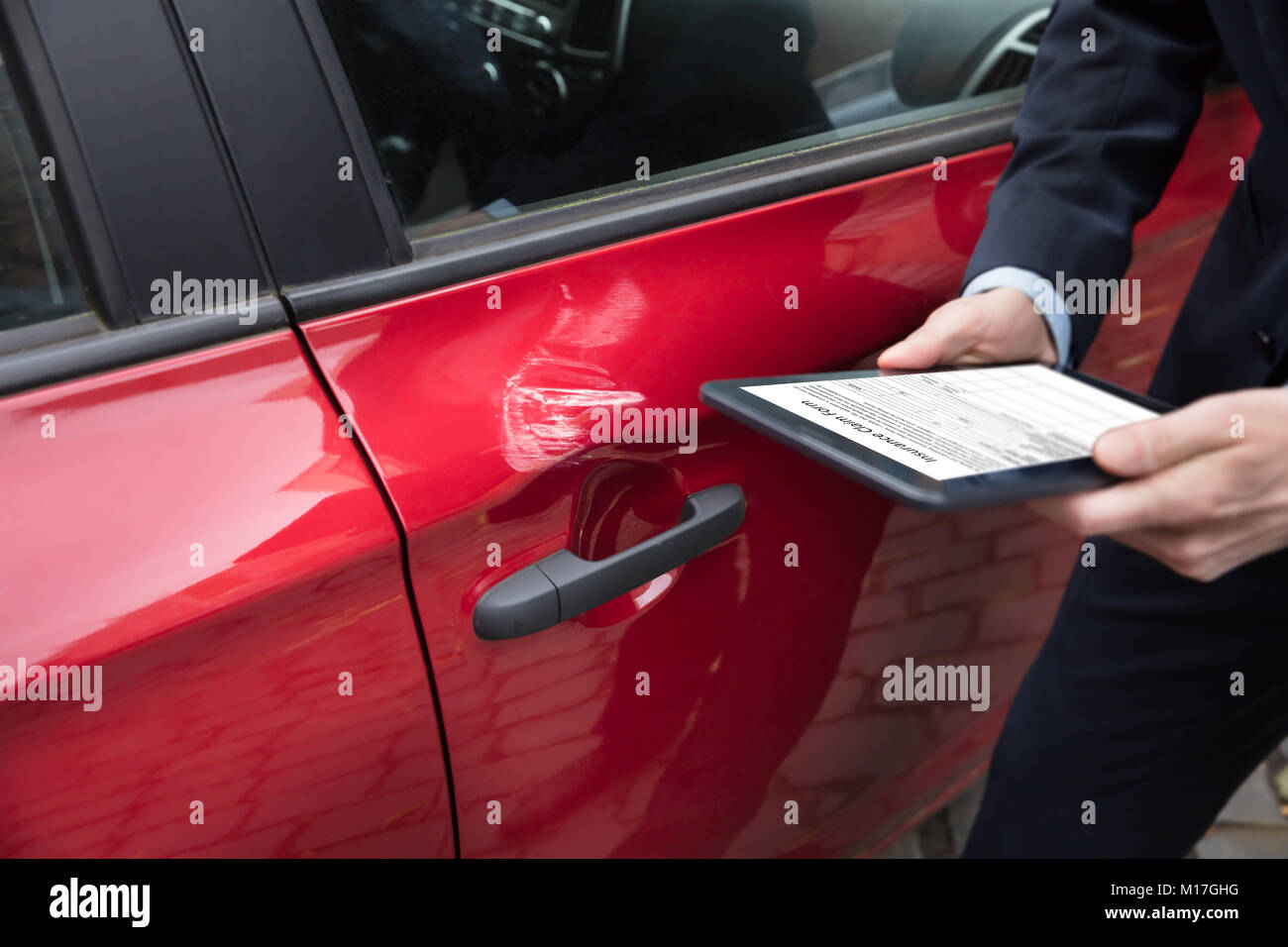 Rotes Auto in der Nähe der Person Hand mit digitalen Tablet Übersicht Versicherung Formular auf dem Bildschirm Stockfoto
