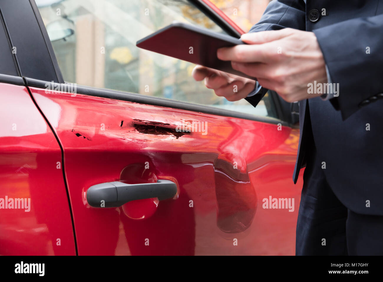 Rotes Auto in der Nähe der Person Hand mit digitalen Tablet Stockfoto
