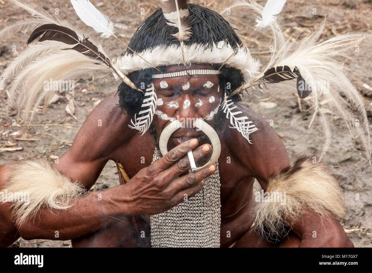 Wamena, Indonesien. Der Leiter der Dani Stamm in ein traditionelles Kleid das Rauchen einer Zigarette in Dugum Dani Dorf. The Baliem Valley in Papua, Irian Jaya. Stockfoto
