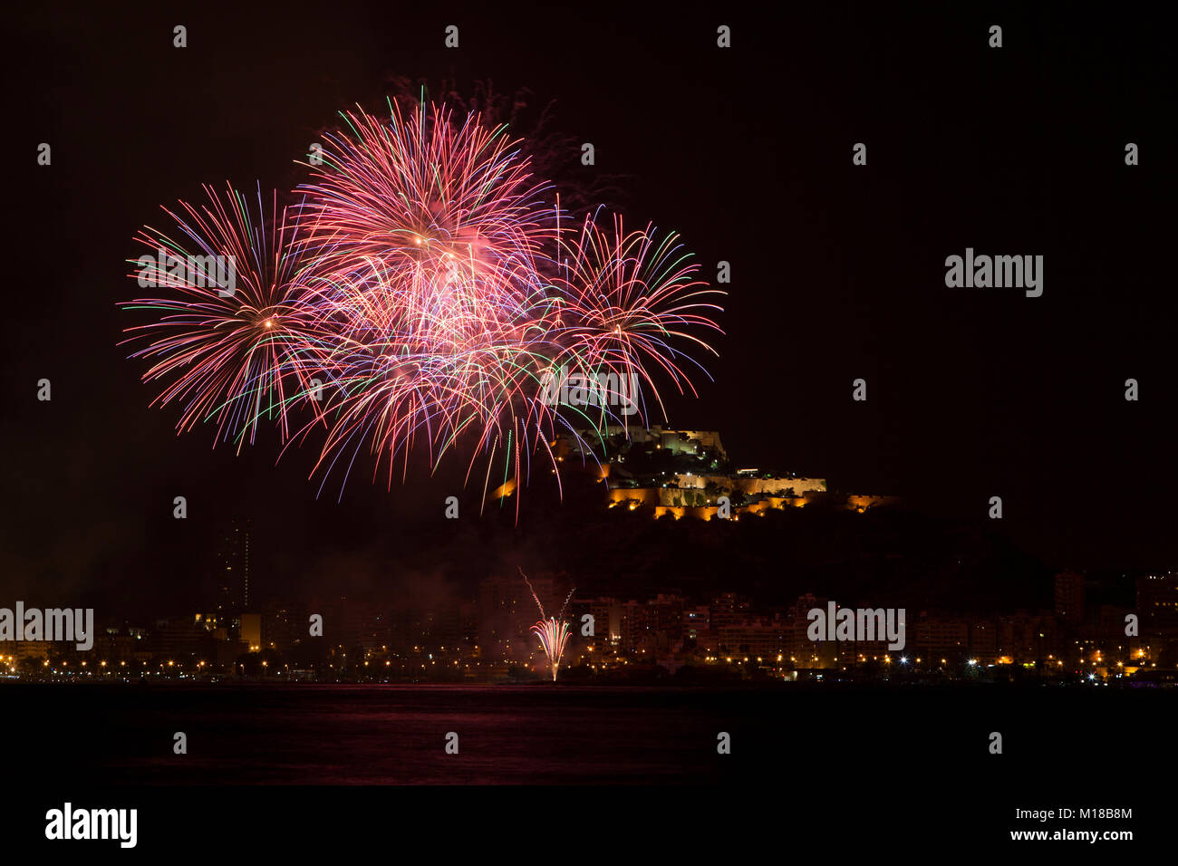 Feuerwerk in San Juan de Alicante mit Santa Barbara im Hintergrund das Schloss, Costa Blanca, Alicante, Spanien. Stockfoto