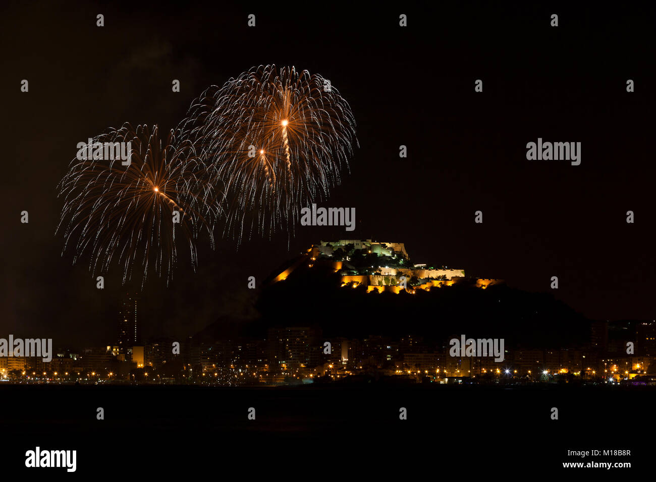 Feuerwerk in San Juan de Alicante mit Santa Barbara im Hintergrund das Schloss, Costa Blanca, Alicante, Spanien. Stockfoto