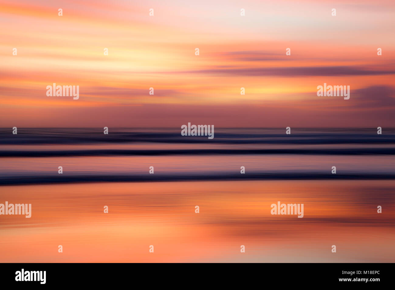 Motion Blur von Meer und Wellen mit einem farbenfrohen Sonnenaufgang. Stockfoto