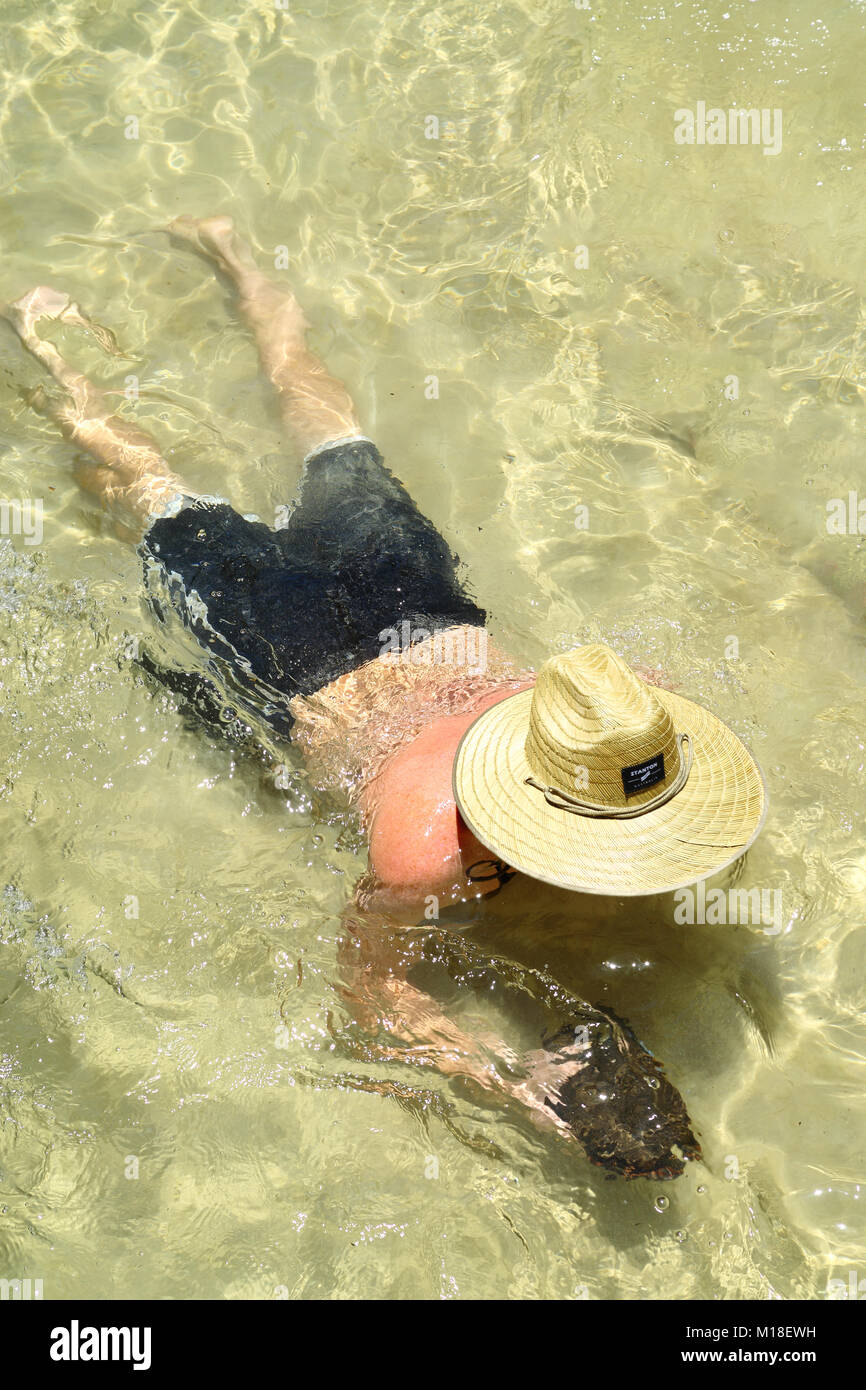 Ein kaukasischer Mann schwebt nach einem seichten Bach oder Fluss auf Fraser Island. Stockfoto