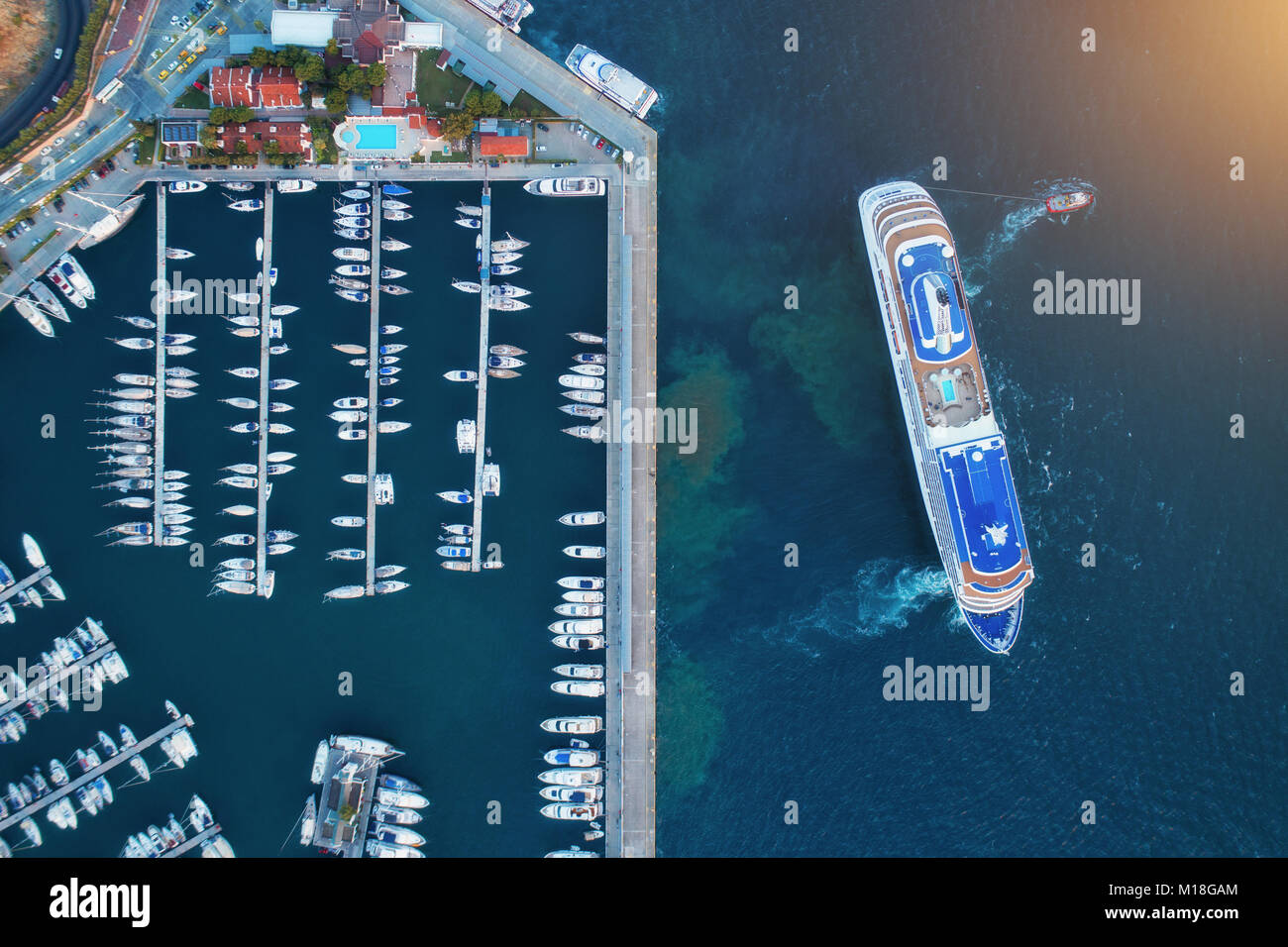 Luftaufnahme von erstaunlichen Boote und große Kreuzfahrtschiff bei Sonnenuntergang. Minimalistischer Landschaft mit Boote und Meer in Marina Bay. Ansicht von oben von drohne von Hafen w Stockfoto