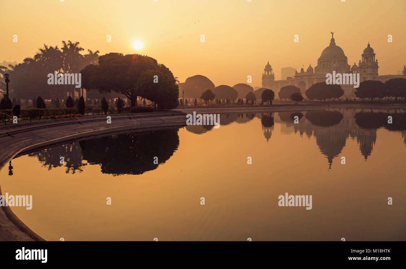 Victoria Memorial Kolkata bei Sonnenaufgang mit Winter Haze und Wasser Reflexionen. Victoria Memorial ist eine koloniale Stadt Architektur in Kolkata, Indien Stockfoto