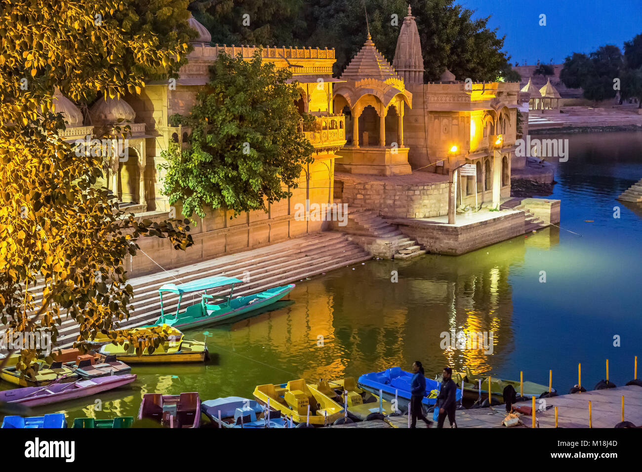 Gadi Sagar (See Gadisar) Jaisalmer mit Nachtbeleuchtung und Touristen mit einem Boot fahren. Stockfoto