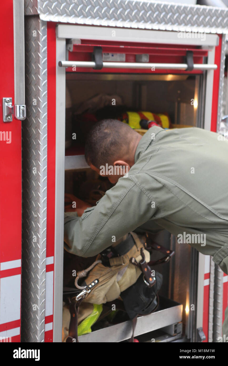 Sgt. Ayham Johnson, ein Flugzeug Rettung und Brandbekämpfung Marine bei der Marine Corps Air Station Miramar stationiert, schaut über Löschausrüstung in einem San Diego Feuerwehr Fahrzeug in San Diego, Kalifornien, 25. Januar. Wechselwirkungen zwischen militärischen und civillian Feuerwehrmänner gibt beiden Parteien Gelegenheit, voneinander zu lernen und Beziehungen, die in Notsituationen helfen könnten. (Marine Corps Stockfoto