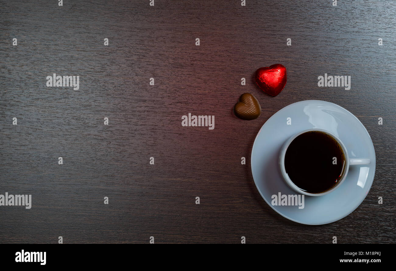 Hintergrund bei einer Tasse Kaffee und Schokolade Süßigkeiten auf dunklen Stockfoto