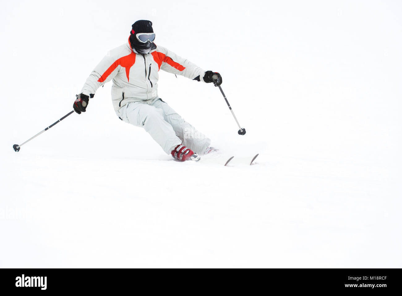 Alpine Skifahrer Skifahren bergab über weißen Schnee Hintergrund Stockfoto