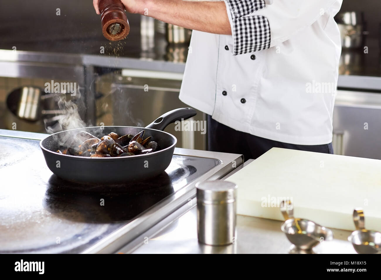 Koch peppering Backofen gedämpfte Muscheln in der Wanne. Stockfoto