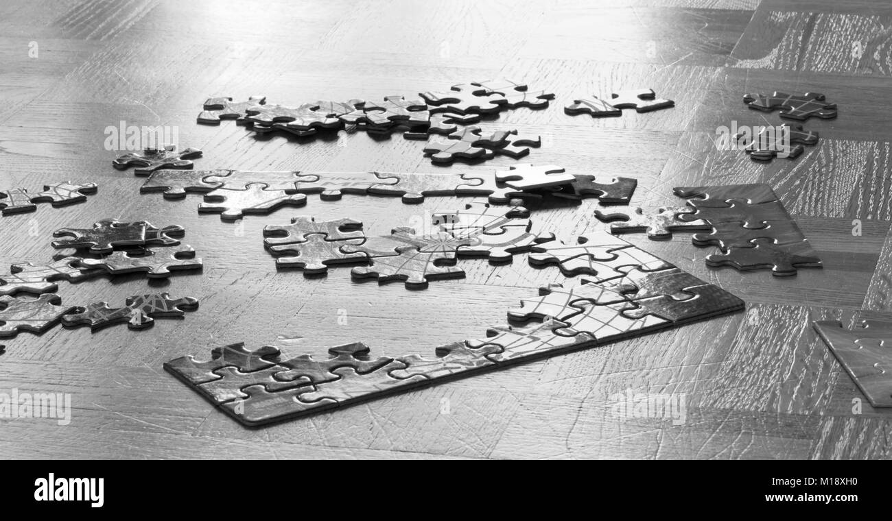 Puzzles auf Holz- alten Fußboden, close-up. Spiel Konzept. Abstrakte schwarzen und weißen Hintergrund mit Mosaik, Puzzle Spiel. Getönt. Stockfoto