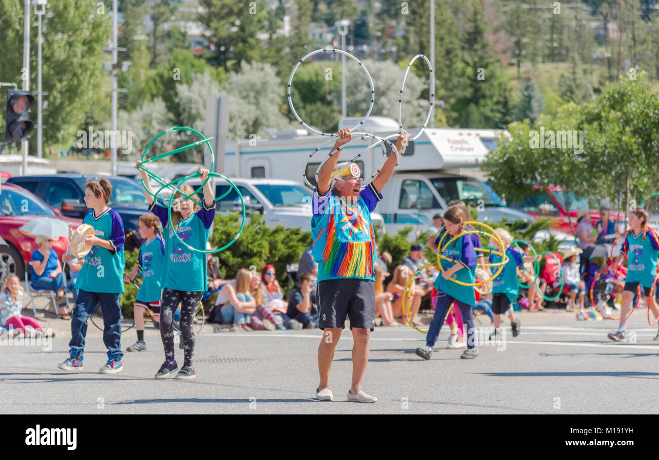 Erste Nationen Elder führt Kinder in die Leistung eines traditionellen Hoop Dance an der jährlichen Stampede Parade in der Innenstadt von Williams Lake. Stockfoto