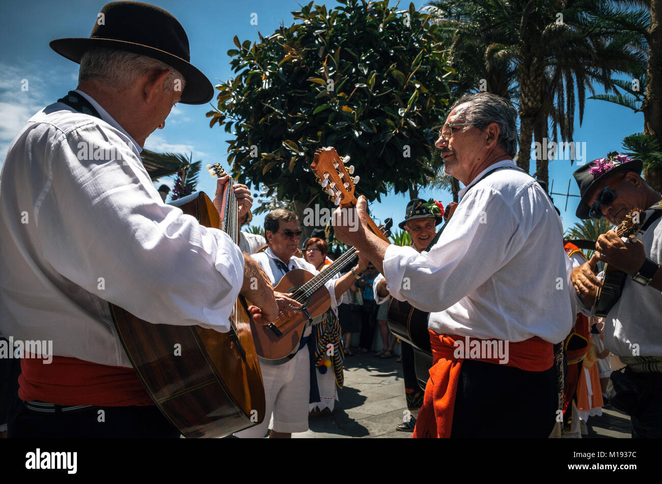 Puerto de la Cruz, Teneriffa, Kanarische Inseln - 30. Mai 2017: Kanaren Menschen in traditionellen Kleidern bekleidet Spaziergang entlang der Straße, Zeichen und Gitarre spielen Stockfoto