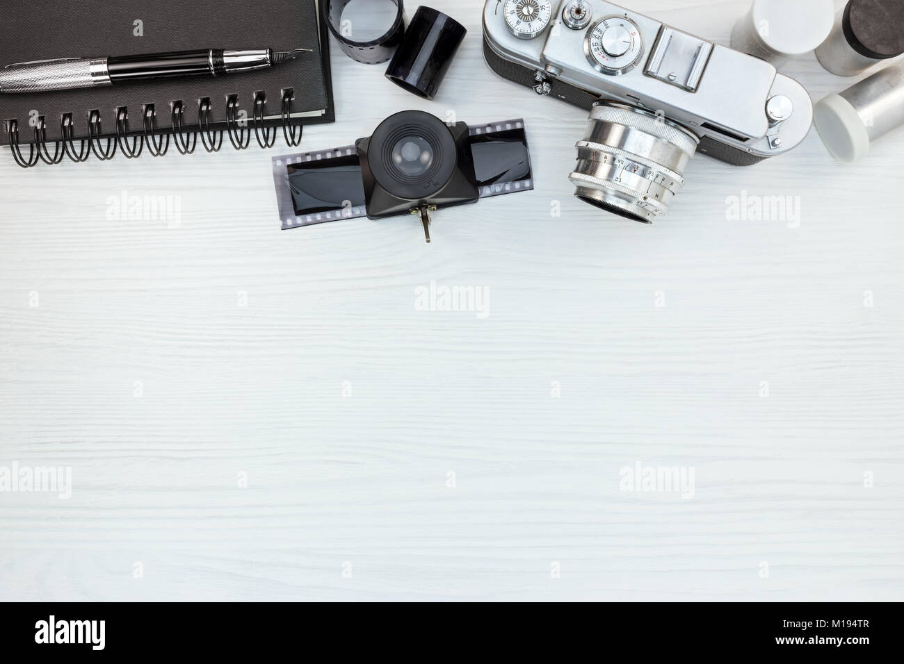 Retro Foto Kamera und negative Filmrollen auf weißem Hintergrund Holz flache Ansicht. alte Erinnerungen stil Konzept. Stockfoto