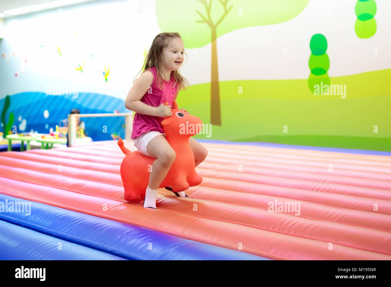 Kind springen auf bunten Spielplatz Trampolin. Kinder springen in Aufblasbare bounce Burg auf Kindergarten Geburtstag. Aktivität und spielen Zentrum für Yo Stockfoto