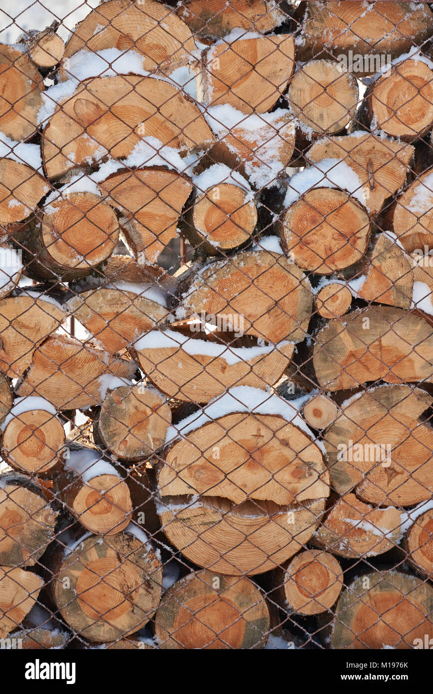 Stapel von Holz Holz bedeckt Verlegung mit Schnee Hintergrund Stockfoto