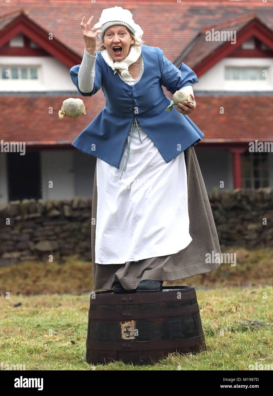 Freiwillige Alison Wilson Kleider wie Agnes Burns (Robert Burns Mutter),  und zeigen Sie, wie sich ein Schleudern haggis an Burns Cottage in Alloway  an der Welt Haggis Schleudernmeisterschaft, Teil der Verbrennungen Feier