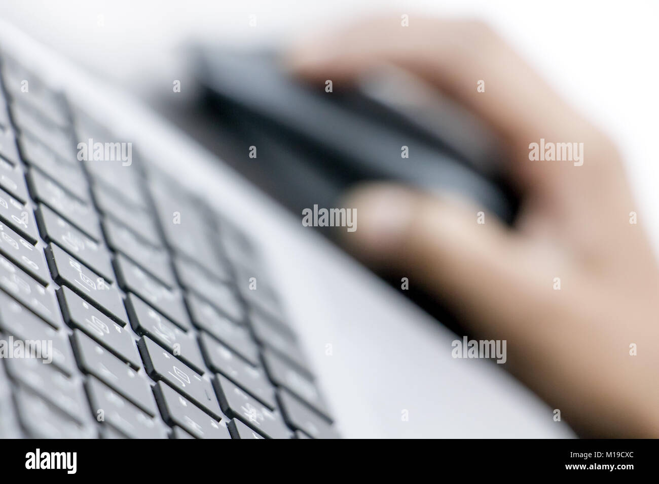 Nahaufnahme der Tastatur mit der Hand auf der Maus in verschwommenen Hintergrund. Stockfoto