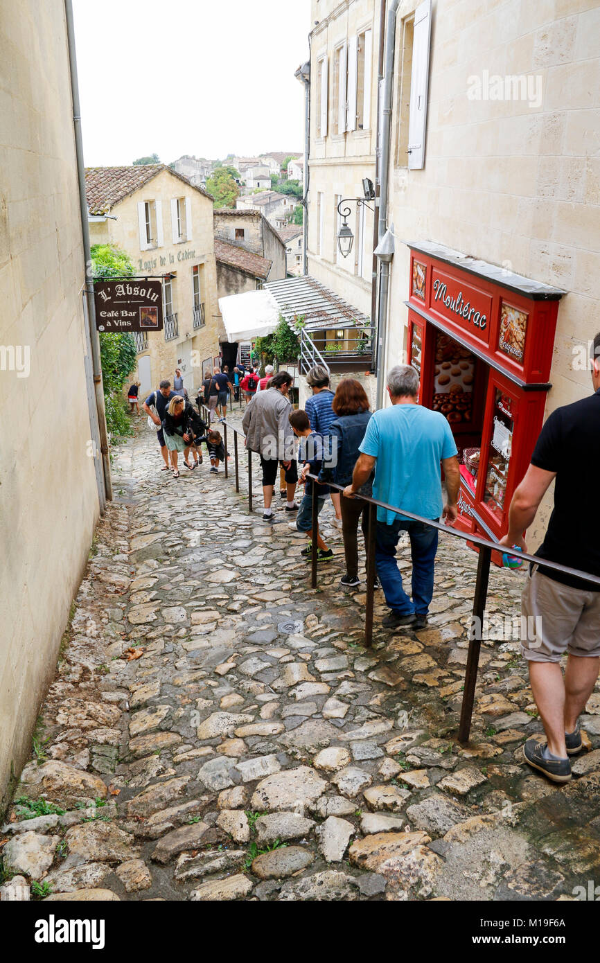 Gruppe von Menschen, die zu Fuß die rutschige Kopfsteinpflaster der Rue du Tertre de La Tente in Saint-Emilion, ein mittelalterliches Dorf in die Bordeaux Weinregion. Stockfoto