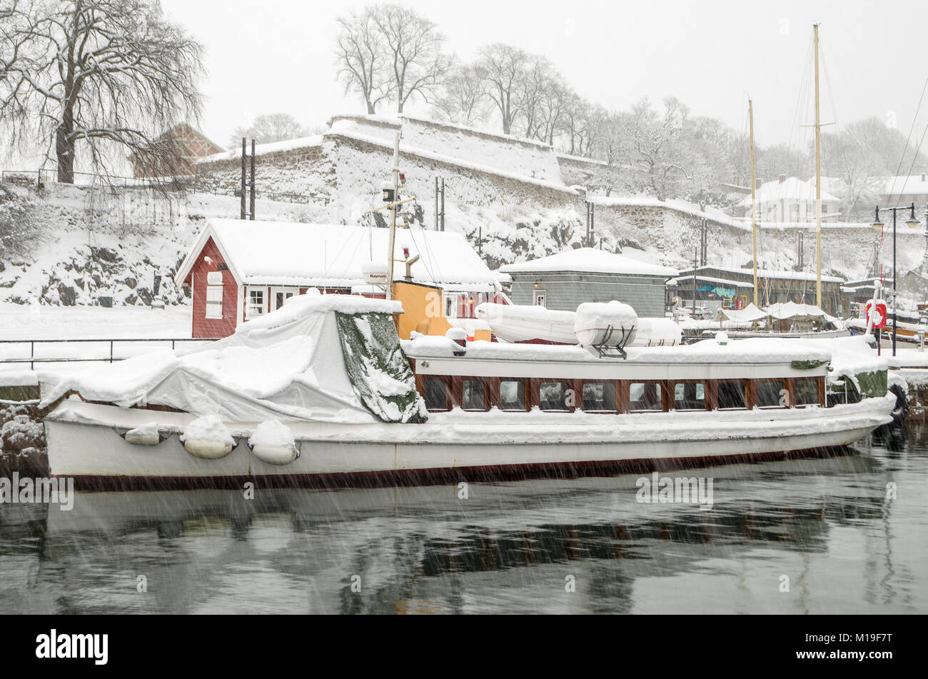 Kleine Passagier Schiff für die Lagerung im Winter bedeckt, von Schnee bedeckt, während Schnee Sturm im Hafen von Oslo, Oslo, Norwegen. Stockfoto