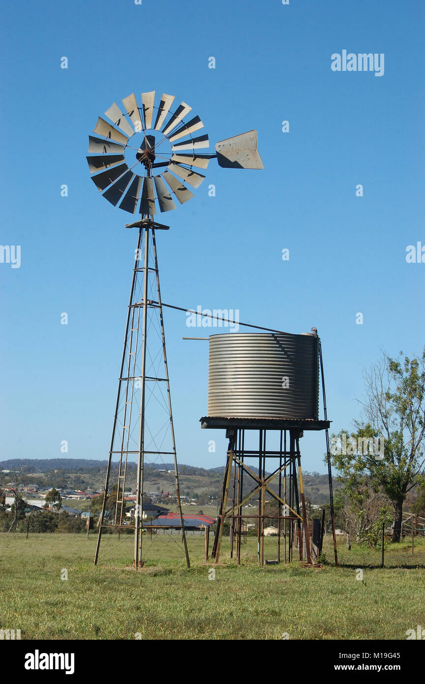 Windmühle und Tankstand im Paddock, Queensland, Australien. Windmühlen sind allgemein für das Pumpen von Wasser aus den Bohrungen oder Dämme, die für die Tierhaltung verwendeten. Stockfoto