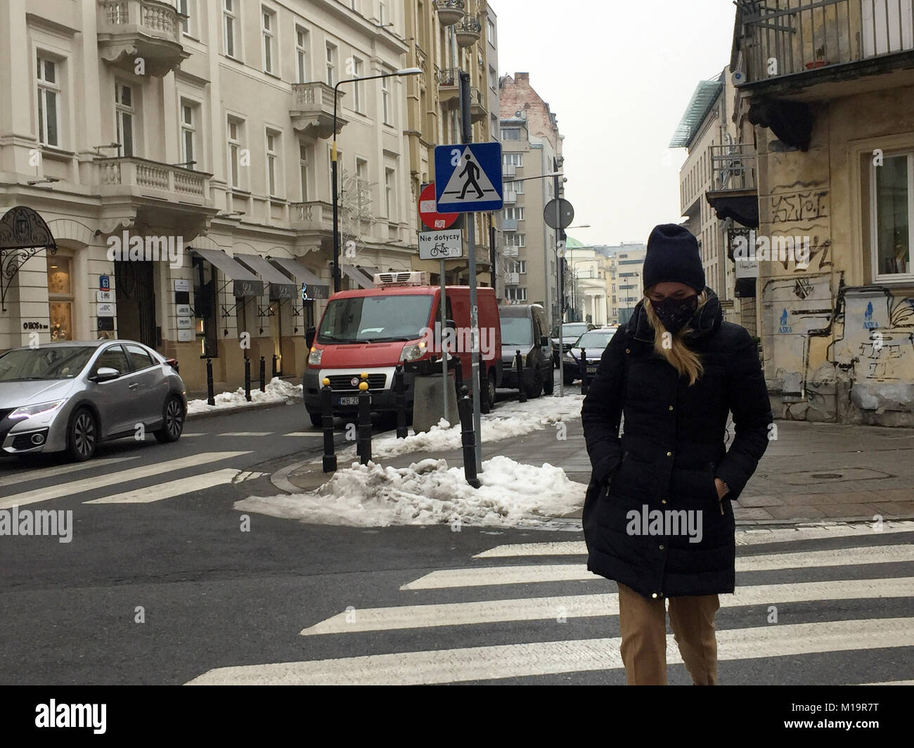 Warschau, Polen. 24 Feb, 2017. Eine junge Frau trägt ein smog Maske überquert die Straße in Warschau, Polen, 24. Februar 2017. Immer mehr polnische Leute beginnen, sich bewusst für die Luftverschmutzung in Ihrem Land zu werden. Das Geschäft mit Anti-Elektrosmog Produkte ist derzeit floriert. Credit: Natalie Skrzypczak/dpa/Alamy leben Nachrichten Stockfoto