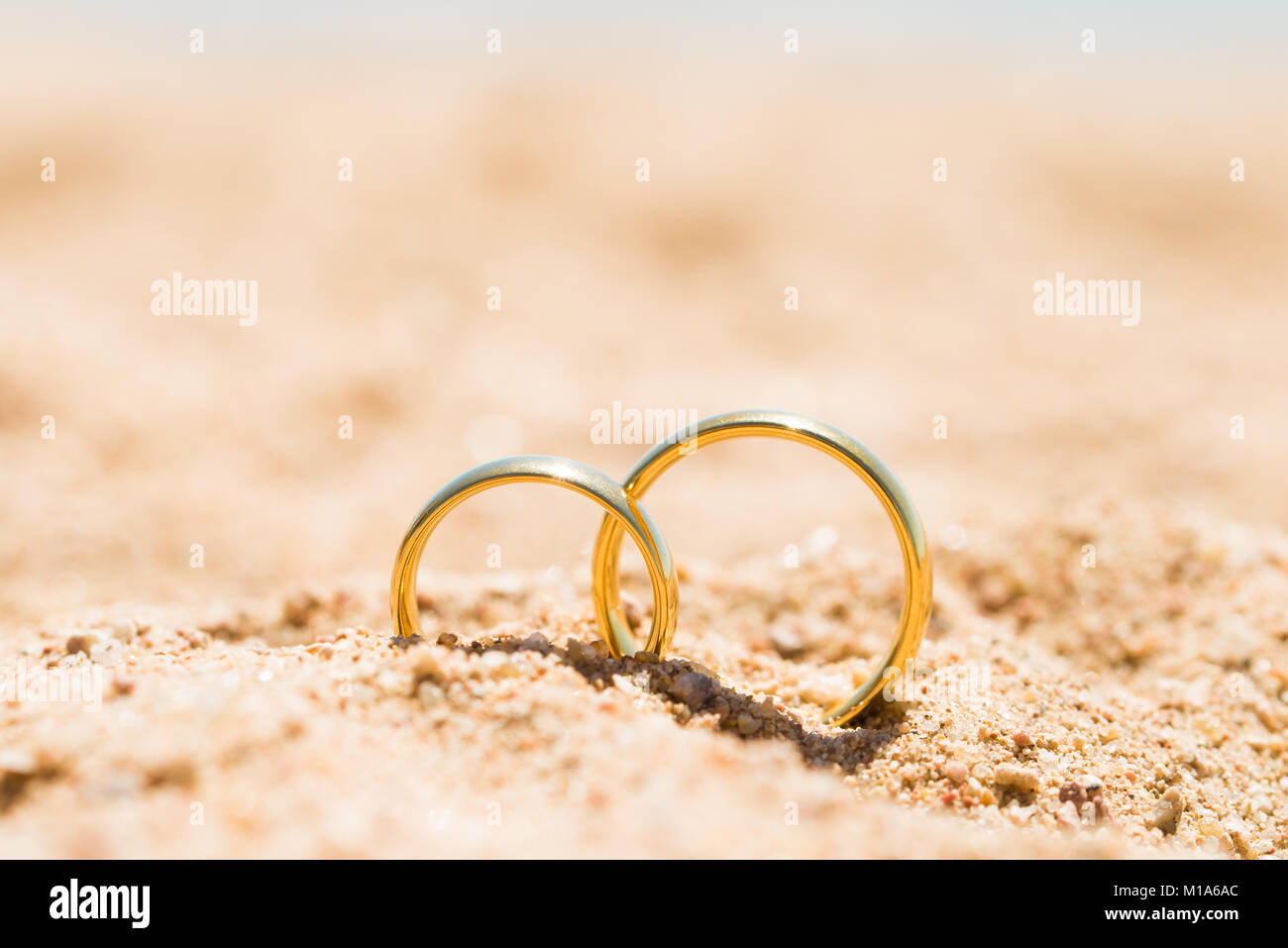 Zwei goldene Ringe in Sand am Strand Stockfotografie - Alamy