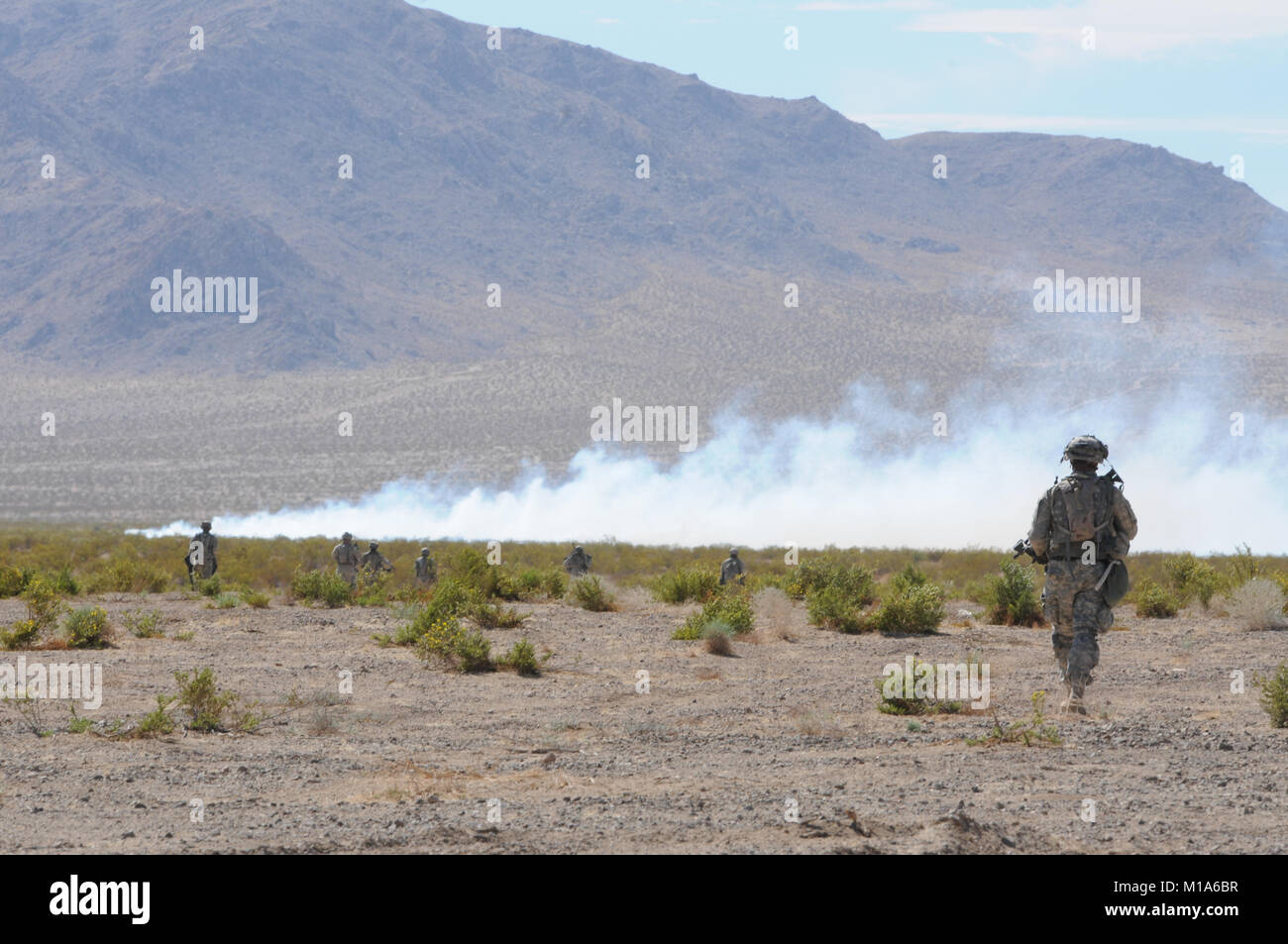 120517-Z-PP 889-016 Oklahoma Army National Guard Soldaten mit Bravo Company, 1.BATAILLON, 184 Infanterie (Licht), in Richtung ihres Ziels als 105 mm Rauch runden 1 Bataillon, 143 Feld der Artillerie Regiment wisp entfernt im Wind. Die 143 sind Teil der 79th Infantry Brigade Combat Team ebenso wie die 184 Th. Dieses Feld Training am 17. Mai im National Training Center in Fort Irwin, Kalifornien, gab allen die Feuerwehr Einheiten zum ersten Mal eine Chance, als ein zu trainieren. (Army National Guard Foto/SPC. Grant Larson) Stockfoto