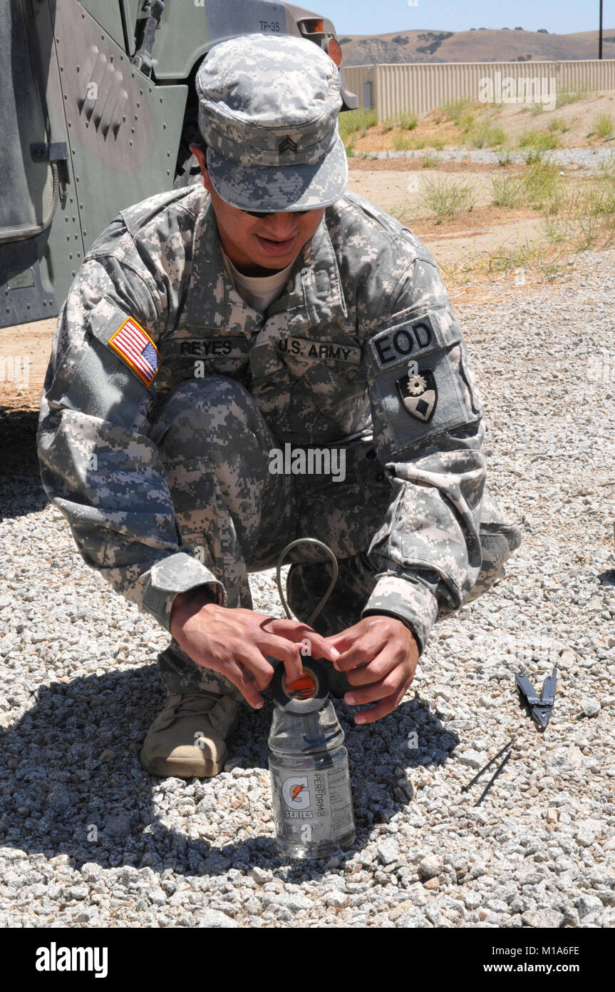 Sgt. Joseph Reyes, eine Beseitigung von Explosivstoffen Techniker mit dem 217Th Beseitigung von Explosivstoffen Unternehmen, Alabama Army National Guard, schafft eine improvisierte Wasser Störungen kostenlos mit detonation Schnur und eine Plastikflasche mit Wasser voll während ihrer jährlichen Schulung im Camp Roberts, Juli 7. Mit Wasser auf ein Gerät Niederlage ist ein sicherer, weil das Wasser die Arbeit der explosiv. Stockfoto