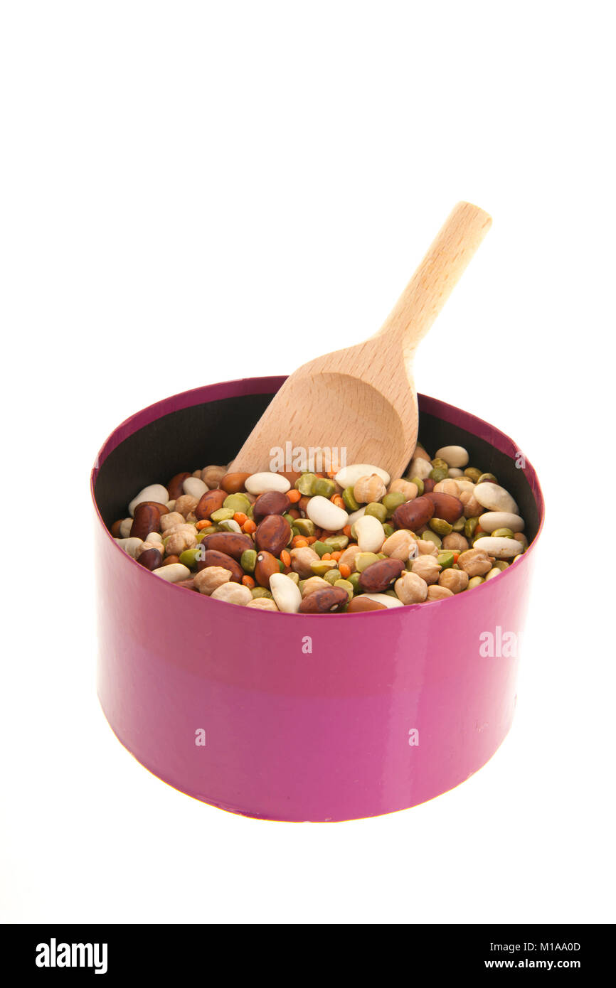Gemischte Hülsenfrüchte in rosa Box mit Holzlöffel auf weißem Hintergrund Stockfoto