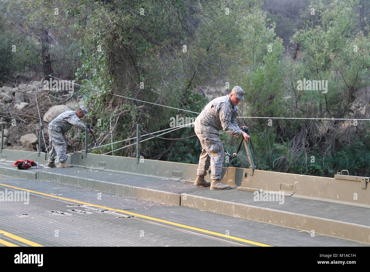 Sgt. 1. Klasse Ben Nievera, Links, noncommissioned Officer verantwortlich für 132 Multirole Bridge Company (MRBC), Oklahoma Army National Guard, und Sgt. Don Kammern prüfen Handläufe über die vorübergehende schwimmende Brücke der Einheit 12.08.7-8 Bei Cache Creek Nationalpark in Yolo County, Kalifornien errichtet. Die Brücke schwebt Neben einer konkreten Struktur im Jahre 1930 erbaut und vor kurzem als unzugänglich für schwere Fahrzeuge. Die 132 gebaut, um die temporäre Struktur so CAL FIRE Geräte können schnell und einfach über die felsigen Feuer zu kämpfen. (U.S. Army National Guard Foto/Staff Sgt. Eddie Siguenza) Stockfoto