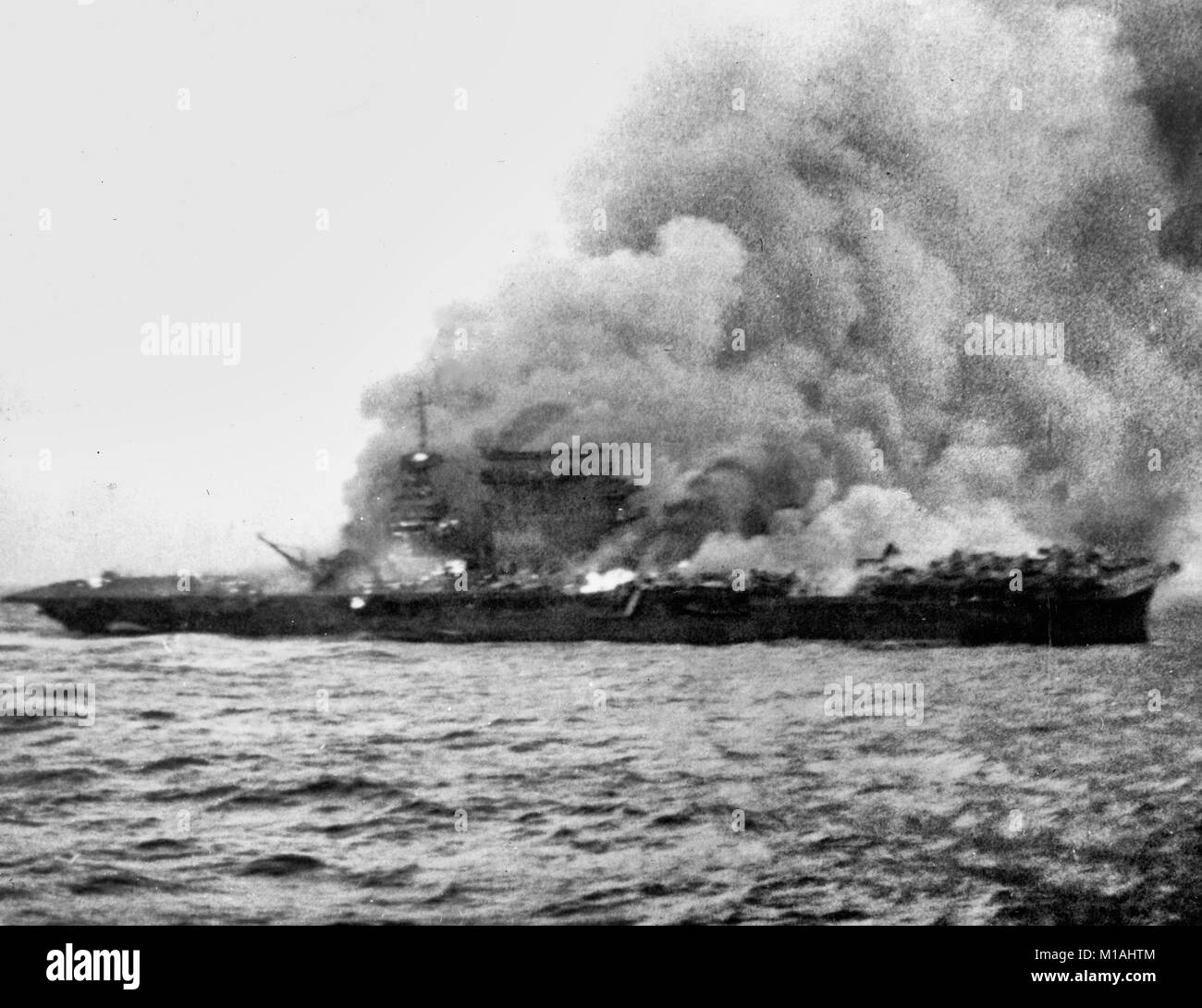 Die US-Marine Flugzeugträger USS Lexington (CV-2), Brennen und Untergang nach ihrer Besatzung verlassenes Schiff während der Schlacht in der Coral Sea, 8. Mai 1942. Hinweis Flugzeuge geparkt aft, wo Brände noch nicht erreicht haben. Stockfoto