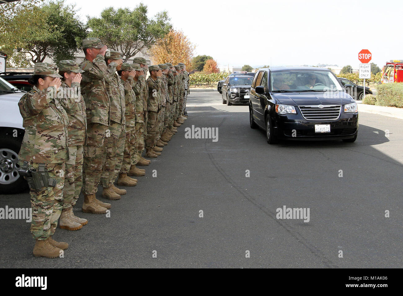 Kalifornien Armee Nationalgarde aus der 185 Military Police Battalion, 49th Military Police Brigade, Salute als Fahrzeug mit einem verstorbenen Freiwilliger Feuerwehrmann rollt in Abteilung das Napa County Sheriff's in Napa, Kalifornien, Okt. 16. Die Salute zahlt den äußersten Respekt für den Verstorbenen, sagt Oberst Robert Paoletti, 49th Commander, die hinter der Gründung stand. Die freiwillige stammte aus Missouri und seine Ursache des Todes wird untersucht, pro Büro des Sheriffs. Mehr als 40 Menschen wurden aus der jüngsten Northern California wildfires enthalten. (Army National Guard Foto: Staff Sgt. E Stockfoto