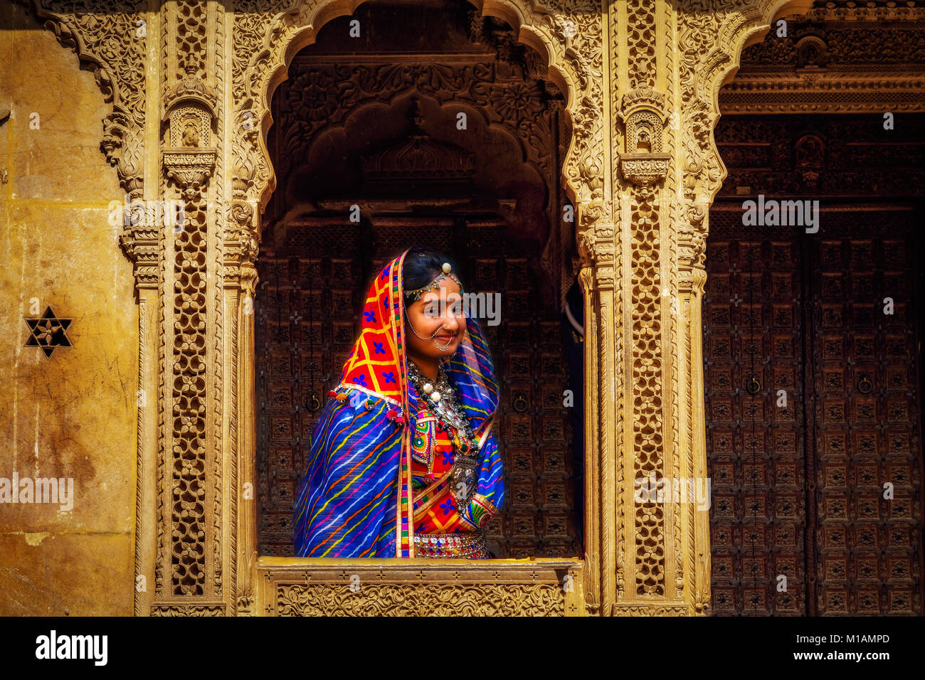 Indische Frau in traditionellen Rajasthani Outfit mit Schmuck Pose an patwon Ki Haveliyan Jaisalmer, Rajasthan. Stockfoto