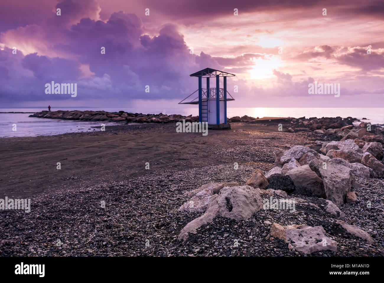 Sonnenaufgang am Meer in Larnaca. Menschliche Silhouette und lifeguard Tower in warmen ultra violette Töne. Stockfoto