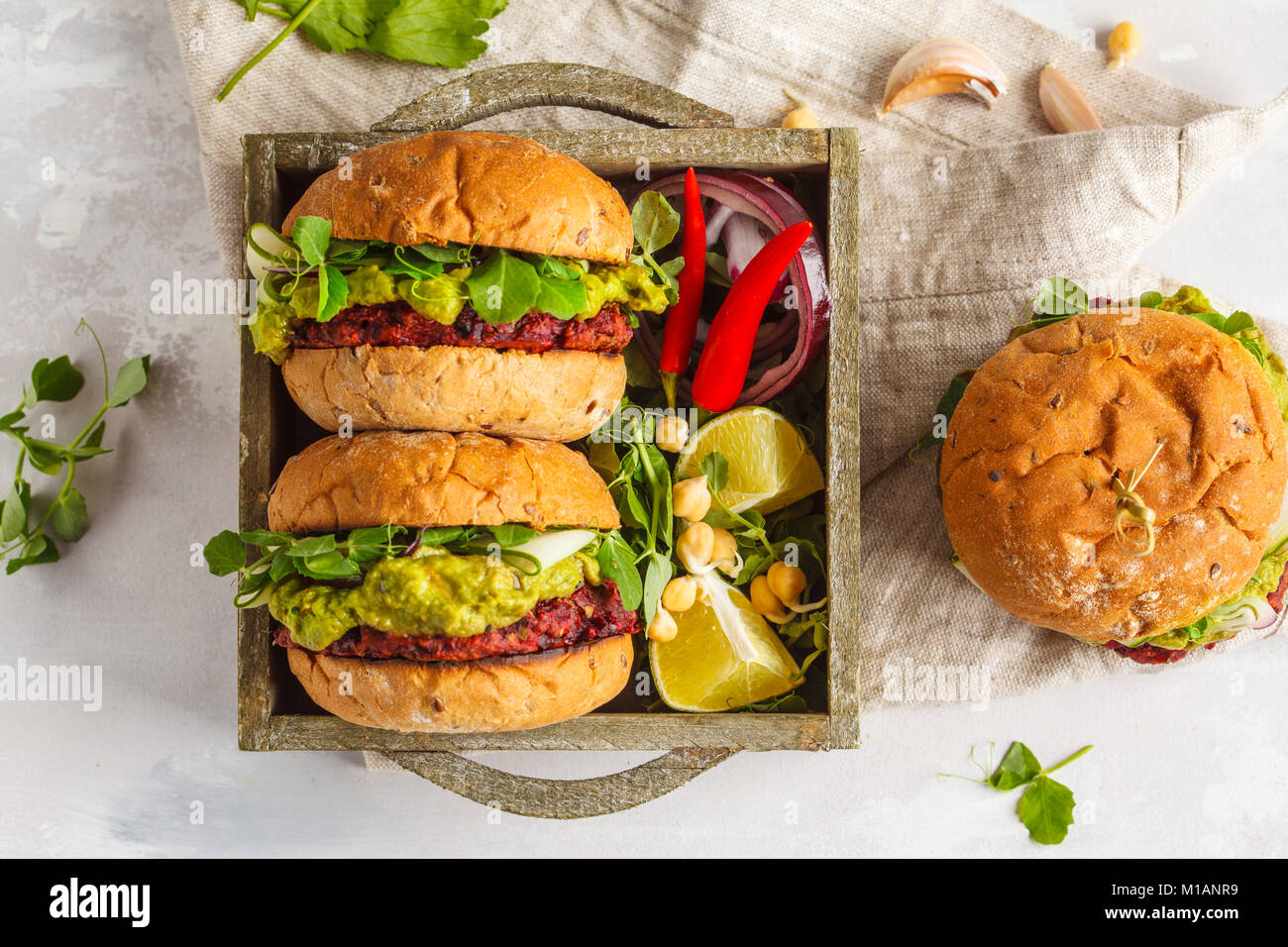 Vegan Zuckerrüben kichererbse Burger mit Gemüse, Guacamole und Roggen Brötchen in Holzkiste. Gesunde vegane Ernährung Konzept. Stockfoto