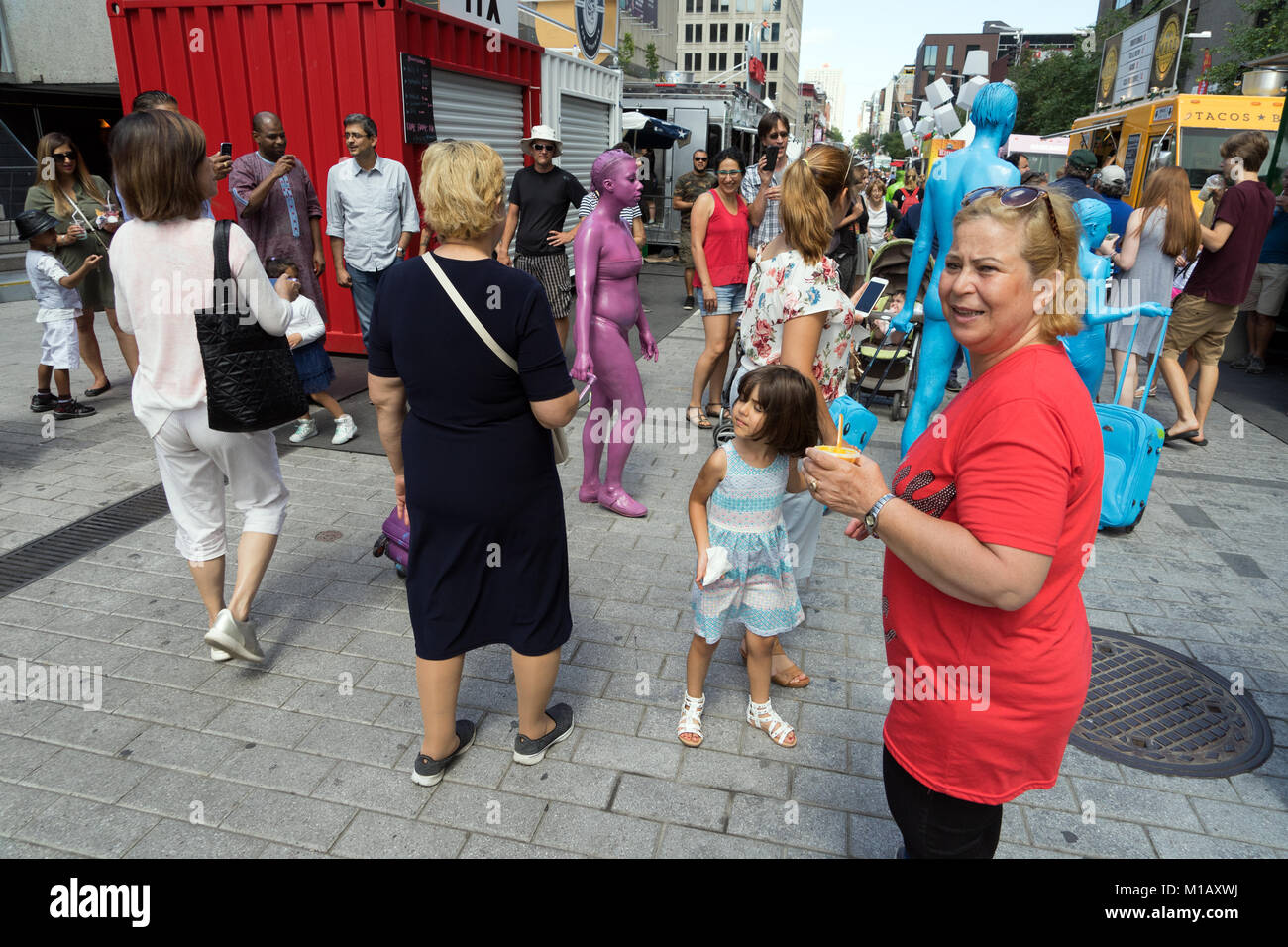 Gaukler, als zu Fuß die geheimnisvolle Regenbogen Menschen" unter der Menge an Ste Catherine Street während des Nur Für lacht Festival in Montreal bekannt. Stockfoto