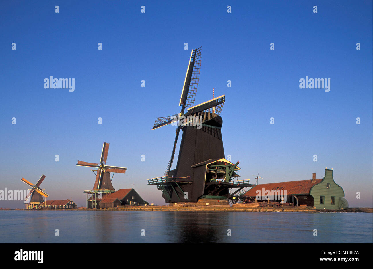 Die Niederlande. Zaanse Schans. Historische Windmühle komplex. Winter. Gefrorener Fluss namens De Zaan. Stockfoto