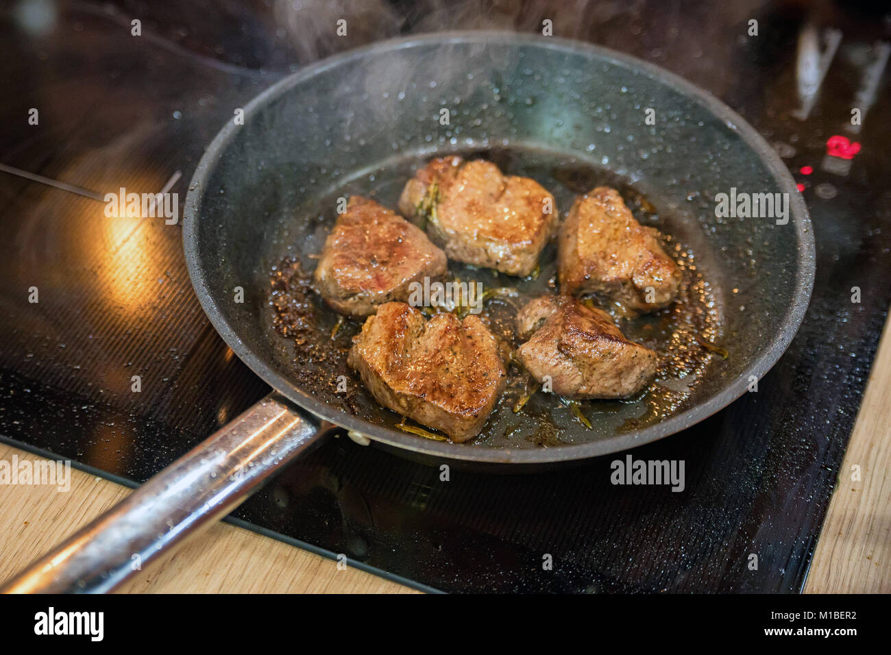 In der Nähe der Pfanne mit Rindfleisch braten in Öl Stockfotografie - Alamy