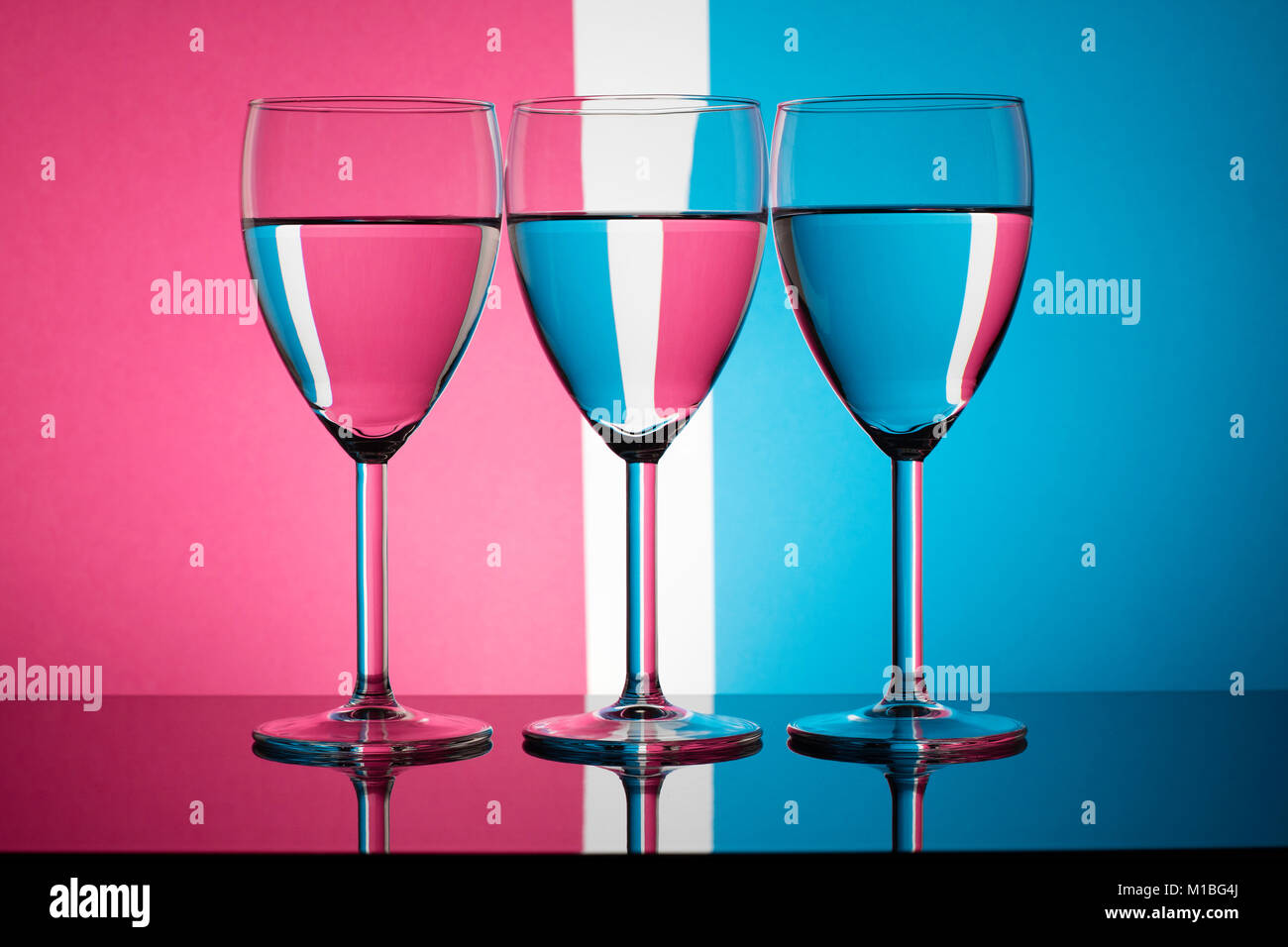 Drei Weingläser brechenden einer pastellfarbenen Hintergrund Stockfoto