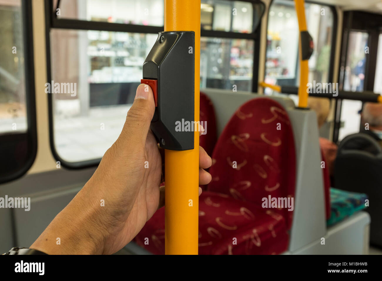 Einen männlichen Fahrgast Drücken der roten Stopptaste mit seinem Daumen auf London Bus, Großbritannien Stockfoto