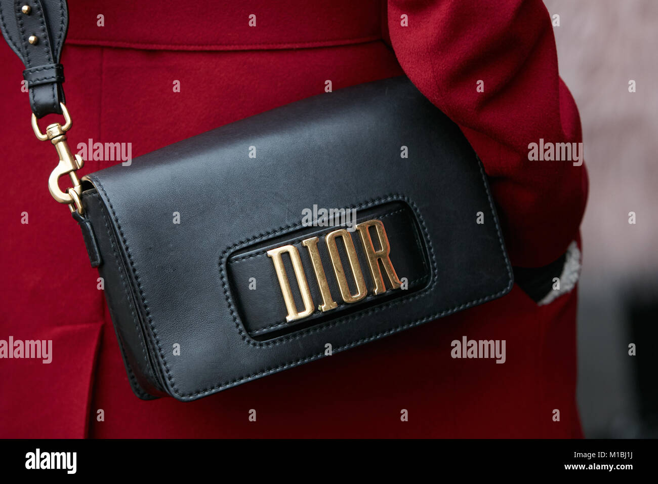 Mailand - Januar 15: Frau mit schwarzem Leder Dior Tasche und roten Mantel vor Pal Zileri fashion show, Mailand Fashion Week street style am 15. Januar 2018 Stockfoto