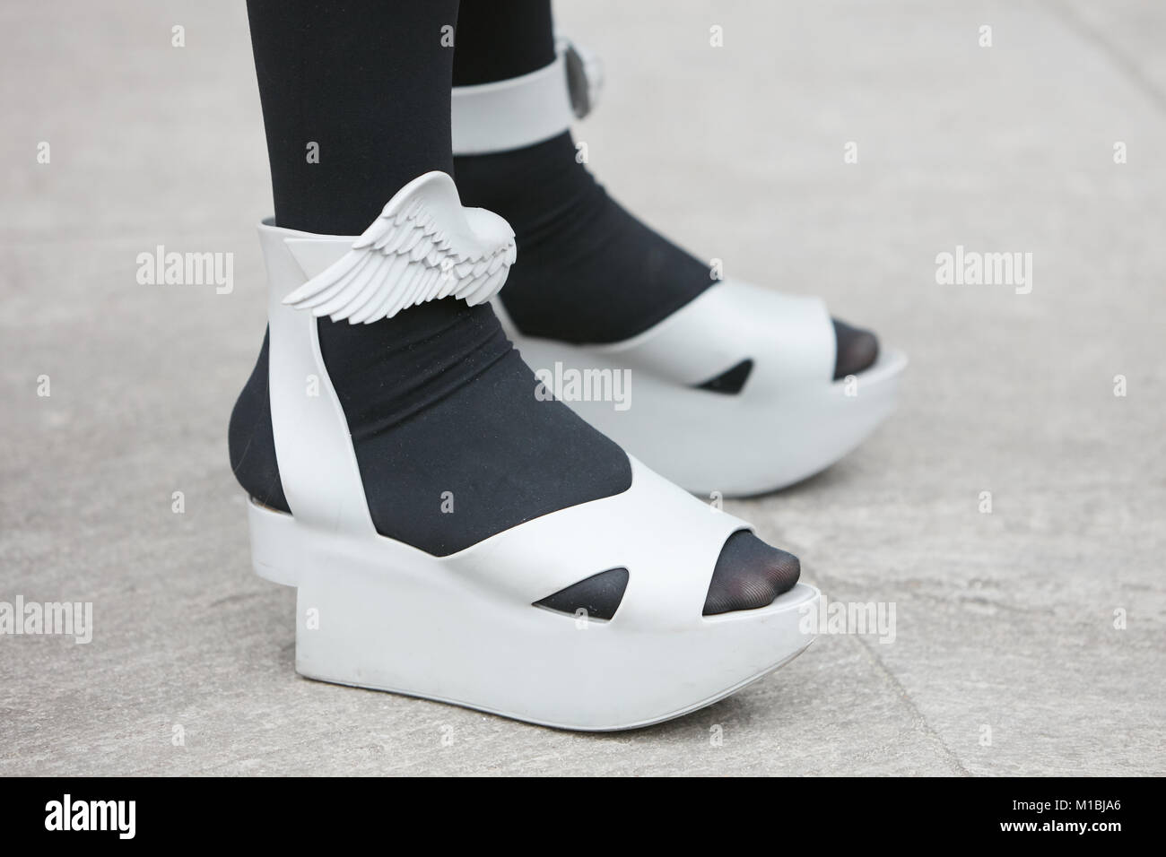 Mailand - Januar 15: Frau mit grau Schuhe mit Flügel und schwarze Strümpfe vor dem Giorgio Armani Fashion Show, Mailand Fashion Week street style Januar Stockfoto